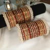 From our Exclusive Collection, this red and maroon bangle set is designed to create an ethereal bridal statement. It features a rich combination of dotted metal bangles in deep maroon, glossy red bangles, and intricate rice work kary in white, maroon, and champagne shades. The look is beautifully finished with luxurious shahi gajray on both ends for a complete royal touch.Perfect for bridal wear, engagement, festive occasions, and traditional events. Deep red and maroon colour palette • Dotted metal bangles • Glossy red finish bangles • Intricate rice work kary • White, maroon, and champagne detailing • Shahi gajray finishing Material Details Bangles: High-quality brass alloy Kary work: Copper alloy Stones & embellishments: Non-precious, premium quality materials Durable, lightweight, and crafted for elegant long wear.