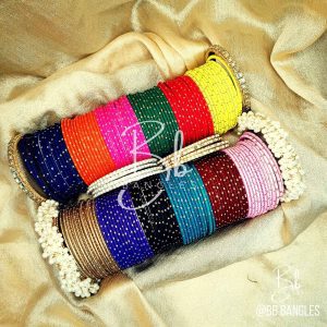 A Selection of 12 Bright Colors alongwith: A pair of Gajra Bangles, A pair of Kundan Karay, 4 Golden thin Pearl and Nug Karay, 4 Silver think Pearl and Nug Karay