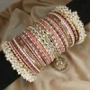 Noor – Tea Pink and Maroon A striking bridal set featuring a Reverse American Diamond Jhumki Kara, Premium Shahi Gajray with golden accents, and matching Indian Sikka Work Karay. Layered with thin karay in pearls, crystals, and wire work, paired with matte and glossy bangles in rich maroon and gold tones. Ideal for weddings, valima, and festive celebrations.