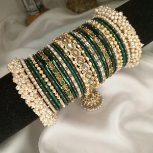 Noor – dark green A striking bridal set featuring a Reverse American Diamond Jhumki Kara, Premium Shahi Gajray with golden accents, and matching Indian Sikka Work Karay. Layered with thin karay in pearls, crystals, and wire work, paired with matte and glossy bangles in rich maroon and gold tones. Ideal for weddings, valima, and festive celebrations.