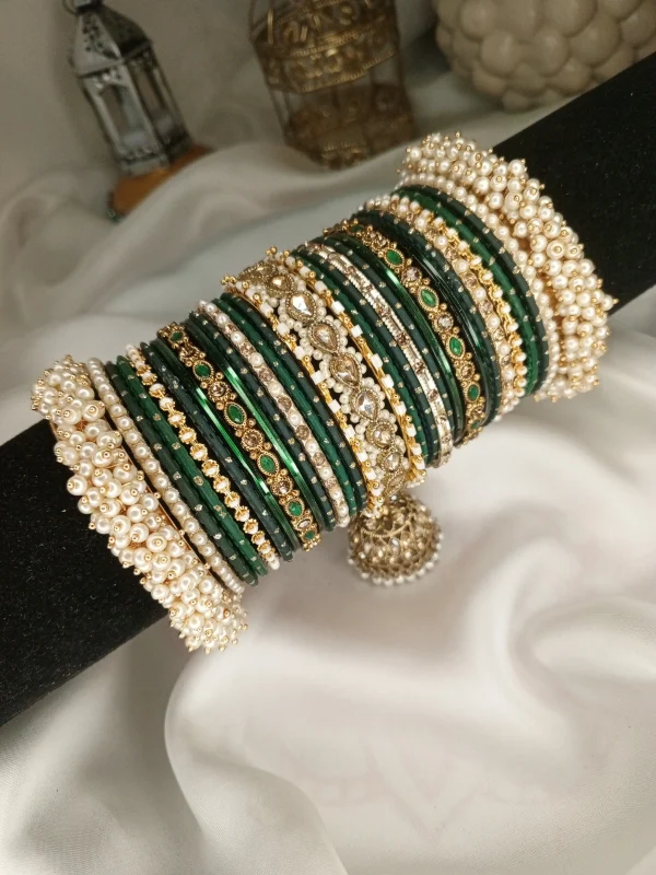 Noor – dark green A striking bridal set featuring a Reverse American Diamond Jhumki Kara, Premium Shahi Gajray with golden accents, and matching Indian Sikka Work Karay. Layered with thin karay in pearls, crystals, and wire work, paired with matte and glossy bangles in rich maroon and gold tones. Ideal for weddings, valima, and festive celebrations.
