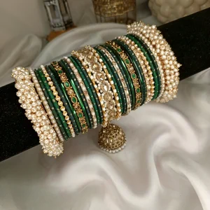 Noor – dark green A striking bridal set featuring a Reverse American Diamond Jhumki Kara, Premium Shahi Gajray with golden accents, and matching Indian Sikka Work Karay. Layered with thin karay in pearls, crystals, and wire work, paired with matte and glossy bangles in rich maroon and gold tones. Ideal for weddings, valima, and festive celebrations.