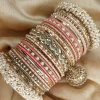 Noor – Shades of Peach A bridal statement set featuring a Reverse American Diamond Jhumki Kara, Premium Shahi Gajray with golden accents, and matching Indian Sikka Work Karay. Enhanced with thin karay in pearls, crystals, and wire work, paired with matte and glossy bangles in elegant peach tones. Perfect for weddings, valima, and special celebrations.