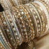 Perfect bangles for your Nikkah event White and Golden: . Adorned with an original reverse American Diamond Jhumki Kara, a pair of Premium Shahi Gajray with Golden Asscent and a pair of Reverse American Diamond Tear Drop Karay, this design is as classic as it gets. With multi thin Karay in Pearl, Crystals and wire work, accompanied by Matt Dot Glitter and Glossy Bangles in a range of white and golden , this set is ideal for nikkah, valima ceremonies, family gatherings, or special invitations for brides, bridesmaids, and graceful mothers alike