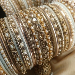 Perfect bangles for your Nikkah event White and Golden: . Adorned with an original reverse American Diamond Jhumki Kara, a pair of Premium Shahi Gajray with Golden Asscent and a pair of Reverse American Diamond Tear Drop Karay, this design is as classic as it gets. With multi thin Karay in Pearl, Crystals and wire work, accompanied by Matt Dot Glitter and Glossy Bangles in a range of white and golden , this set is ideal for nikkah, valima ceremonies, family gatherings, or special invitations for brides, bridesmaids, and graceful mothers alike