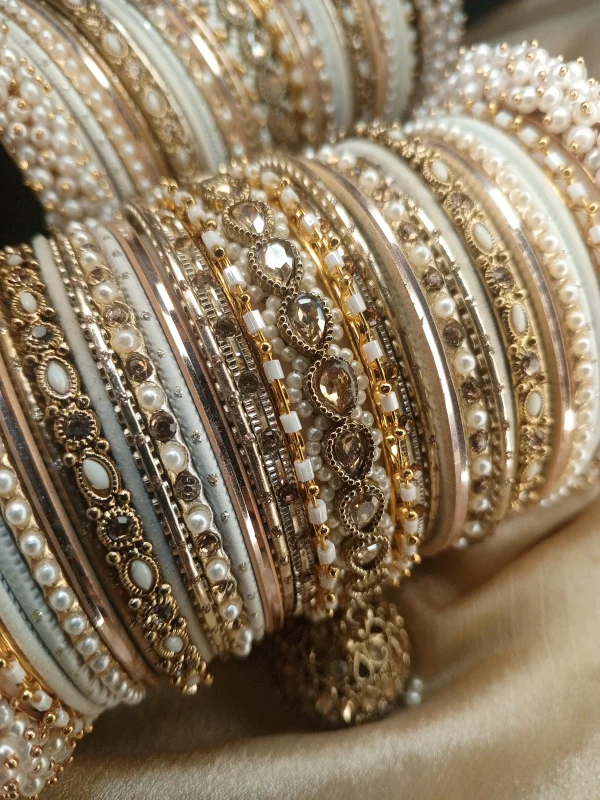 Perfect bangles for your Nikkah event White and Golden: . Adorned with an original reverse American Diamond Jhumki Kara, a pair of Premium Shahi Gajray with Golden Asscent and a pair of Reverse American Diamond Tear Drop Karay, this design is as classic as it gets. With multi thin Karay in Pearl, Crystals and wire work, accompanied by Matt Dot Glitter and Glossy Bangles in a range of white and golden , this set is ideal for nikkah, valima ceremonies, family gatherings, or special invitations for brides, bridesmaids, and graceful mothers alike