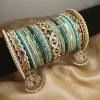 This exclusive jewelry set blends heritage artistry with a contemporary premium feel. Featuring a multi-nug kara design enhanced with a center jewel-tone kara, the set is styled in rich sea jewel hues — perfect for brides and guests who value elegance and cultural sophistication.The reverse ad jhumki elements add movement and delicate charm, giving this set a classic finish that pairs beautifully with wedding lehengas.