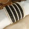 Elevate your festive ensemble with our most-trending Elara set. Perfectly balancing tradition with a clean, sophisticated aesthetic, this set is an essential for your Eid bangles collection. Featuring a classic dozen-bangle core accented by our signature 7 pearl chori dividers, it offers a refined sparkle that transitions effortlessly from formal weddings to intimate