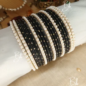 Elevate your festive ensemble with our most-trending Elara set. Perfectly balancing tradition with a clean, sophisticated aesthetic, this set is an essential for your Eid bangles collection. Featuring a classic dozen-bangle core accented by our signature 7 pearl chori dividers, it offers a refined sparkle that transitions effortlessly from formal weddings to intimate