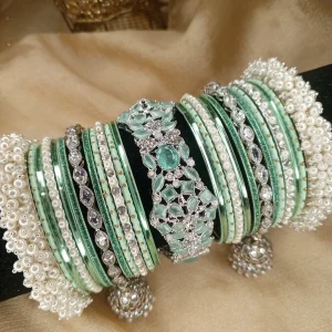 Exclusive Mint Green & Silver Set ✨Elevate your bridal or festive look with our exquisite mint green and silver bangle set! Featuring a center mint green & silver kara, paired with two teardrop kundan jhumki karas and pearl-accented silver Shahi Gajray, this set blends elegance and tradition perfectly.Perfect for weddings, valima ceremonies, and special celebrations.