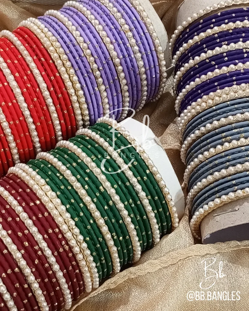 Elevate your festive ensemble with our most-trending Elara set. Perfectly balancing tradition with a clean, sophisticated aesthetic, this set is an essential for your Eid bangles collection. Featuring a classic dozen-bangle core accented by our signature 7 pearl chori dividers, it offers a refined sparkle that transitions effortlessly from formal weddings to intimate