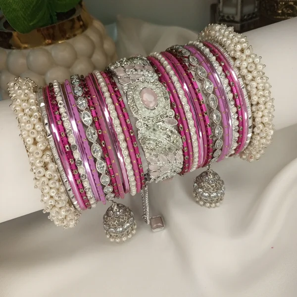 Make a statement with our stunning Falsai-toned bangle set! Featuring a center Falsai & silver kara, paired with two teardrop kundan jhumki karas and pearl-accented silver Shahi Gajray, this set brings elegance and tradition together in perfect harmony. Ideal for weddings, valima ceremonies, and special celebrations.