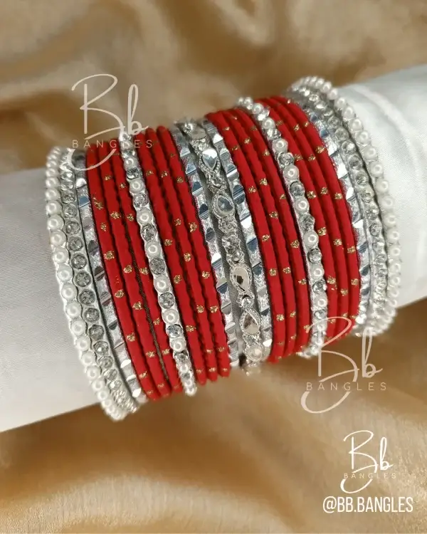 Make a bold and graceful statement with the Mirha set. This captivating stack features a deep crimson red base contrasted against brilliant, high-shine silver accents. Designed to enhance your look with a touch of royal flair, it combines the shimmer of silver mirror-work karas with delicate pearl detailing. Whether it’s for a bride, a festive Eid celebration, or a premium bridesmaid gift, the Mirha set is the ultimate accessory for those who love timeless elegance with a modern silver edge.