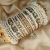 Hoor is a handcrafted white and gold bridal bangle set featuring intricate kundan kary, elegant teardrop stone detailing, a statement teardrop jhumki charm, and sahi pearl gajray on both ends. Perfect for bridal, nikkah, walima, and festive wear. • White and gold classic combination • Detailed kundan kary work • Teardrop crystal stones • Attached jhumki charm • Sahi pearl gajray finish